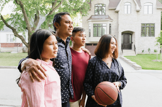 Newcomer-family-with-two-teens-standing-in-front-of-residential-homes-1