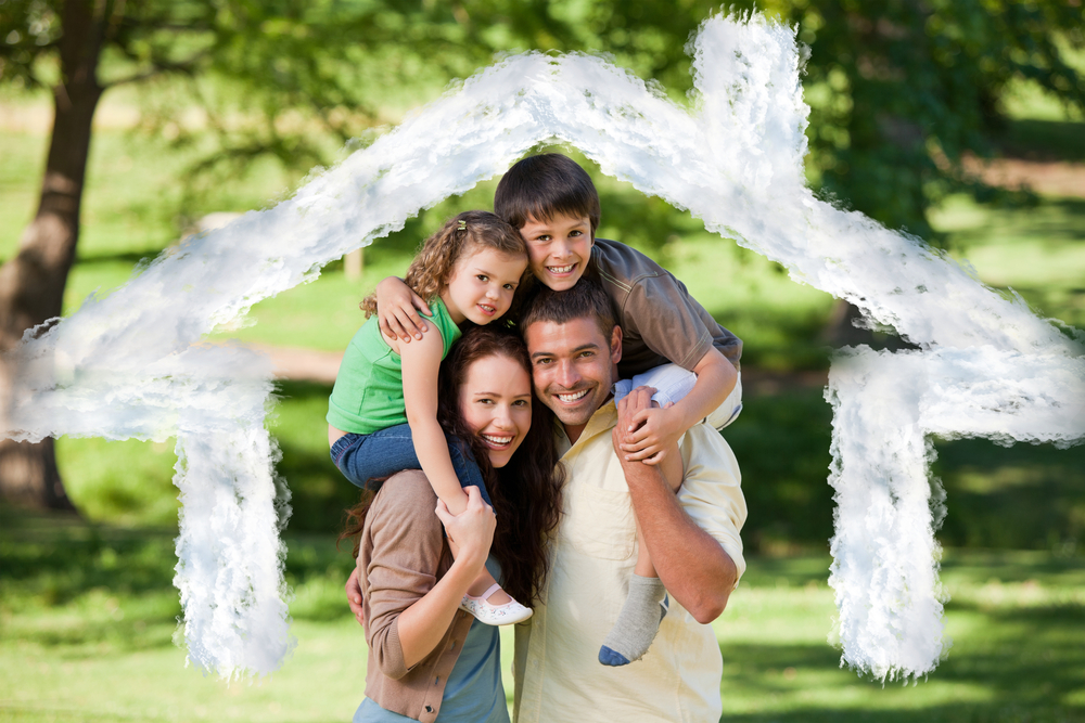 Parents giving children a piggyback against house outline in clouds